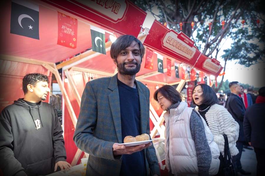 Pakistani stall owner Kaleem Akram serving traditional pakoras to visitors at a Chinese New Year fair in Chongqing.